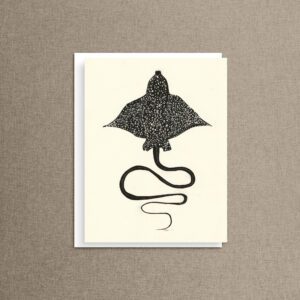 A spotted eagle ray with a cream background against a soft linen background.