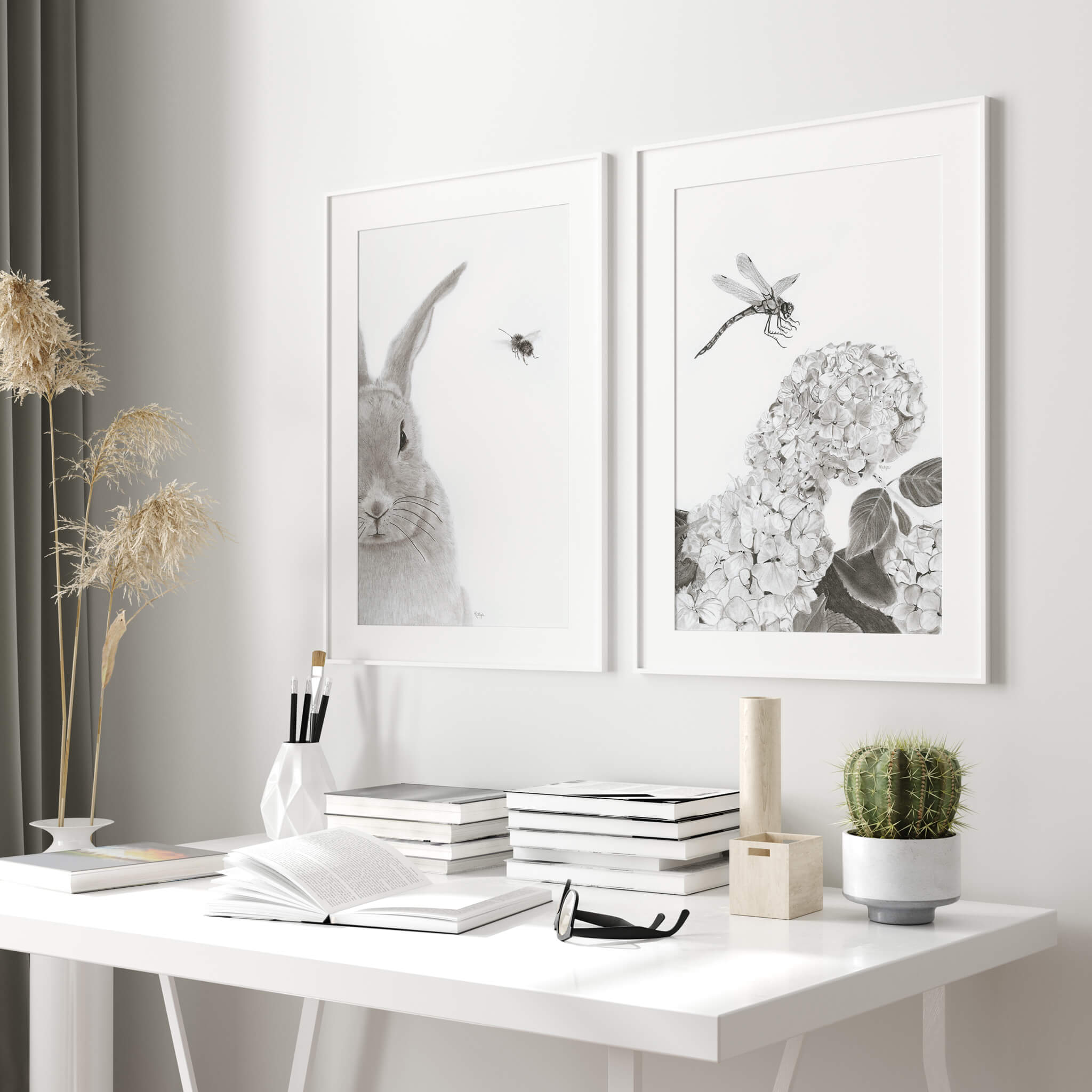 Touchdown dragonfly art print and Honey Bunny rabbit art print framed side by side on a white desk