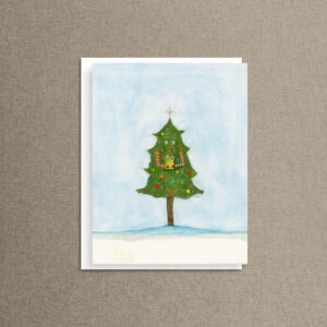 Funny Christmas card of a wide-eyed watercolor Christmas tree in boots holding out a gift, on a white envelope over taupe linen