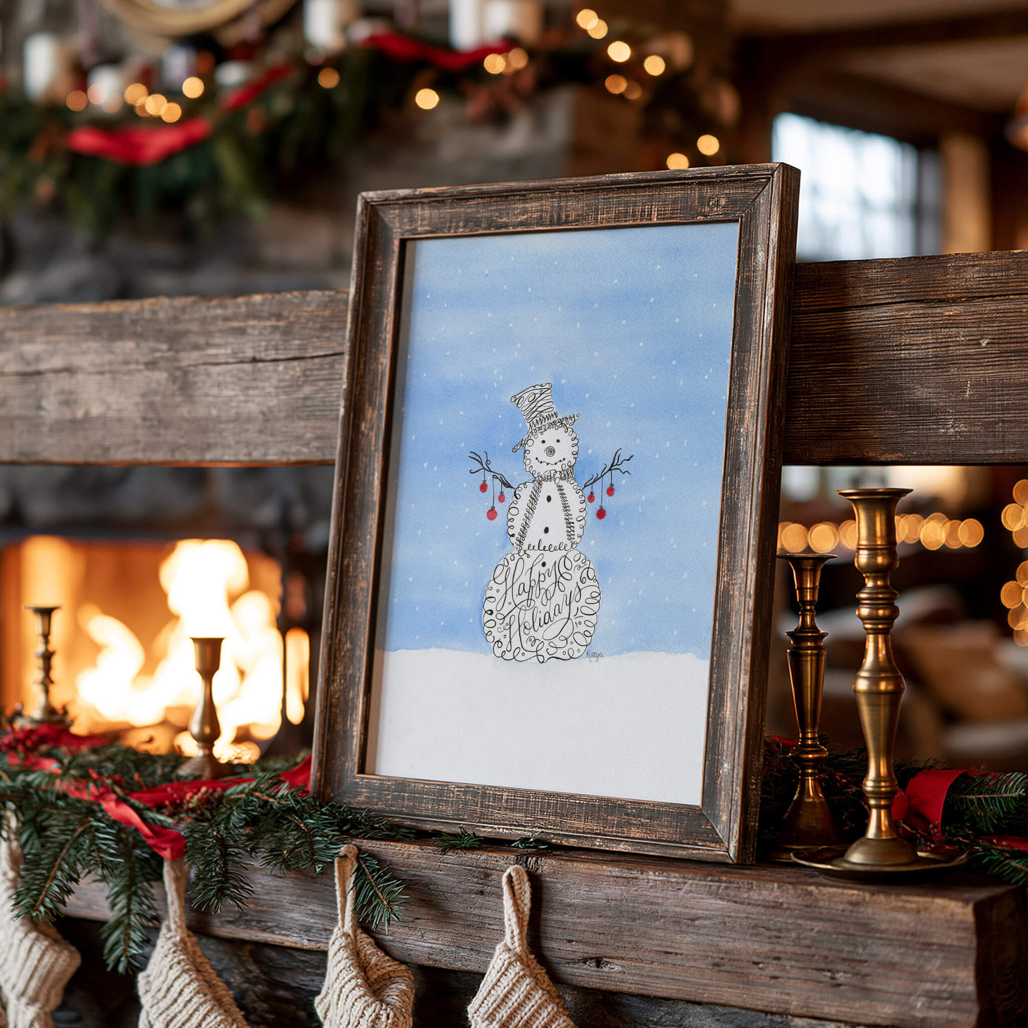 Snowman watercolor painting of a calligraphy snowman in a rustic wood frame, leaning on a timber fireplace mantel with brass candlesticks, pine garland and knit stockings