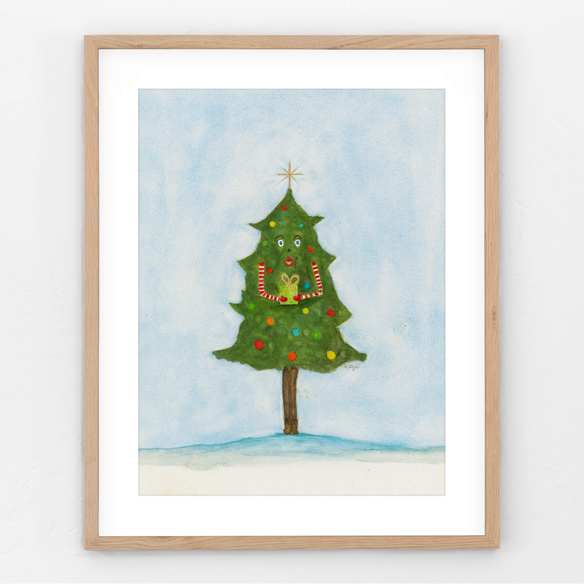 Original Christmas painting of a whimsical watercolor tree in boots holding out a gift, shown in a light oak frame on a white wall