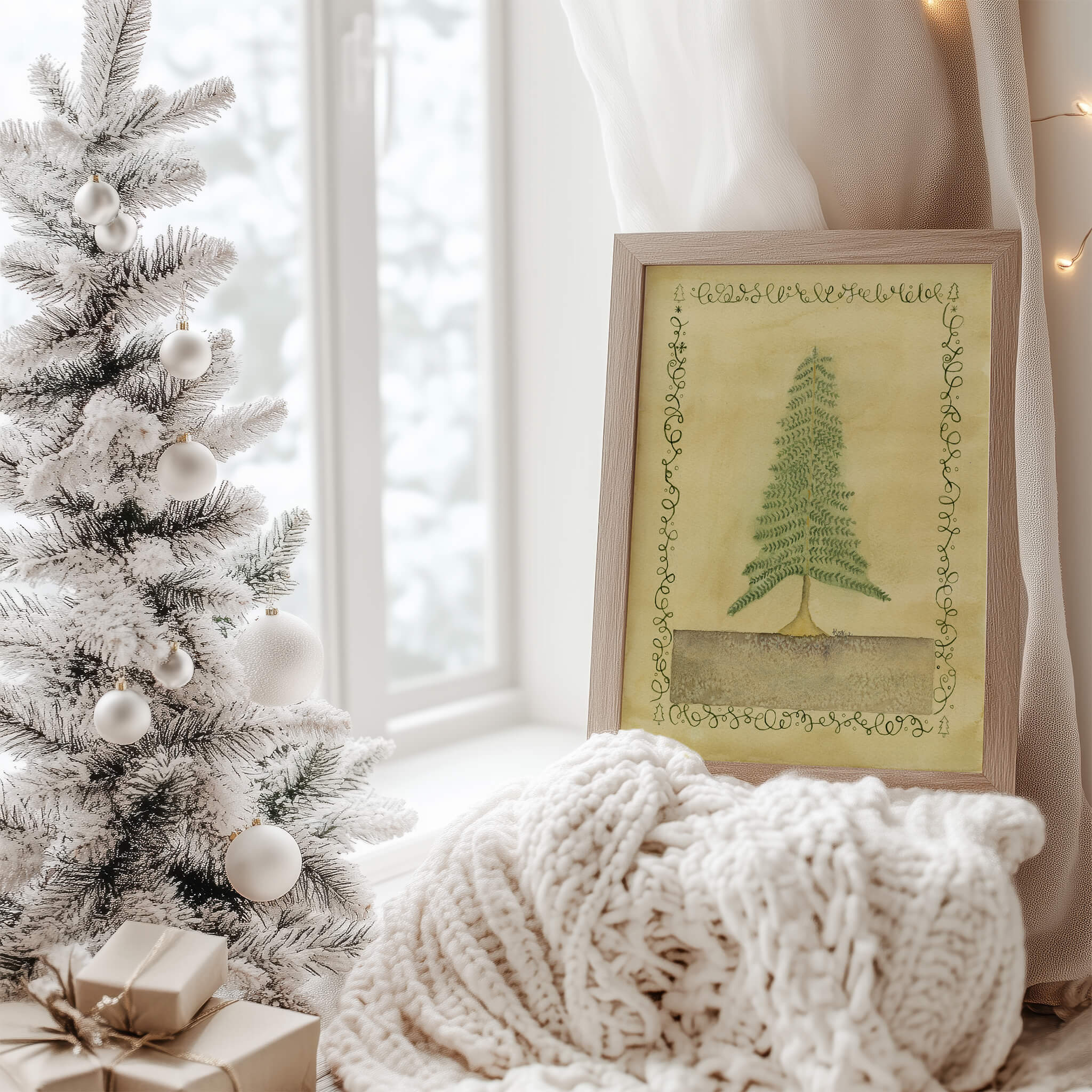 Original pine tree watercolor painting on a windowsill beside a flocked Christmas tree and knit blanket