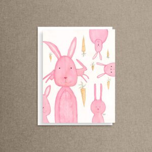Whimsical bunny rabbit note card featuring pink watercolor rabbits hopping among tiny carrots on a soft white background — blank inside stationery card.