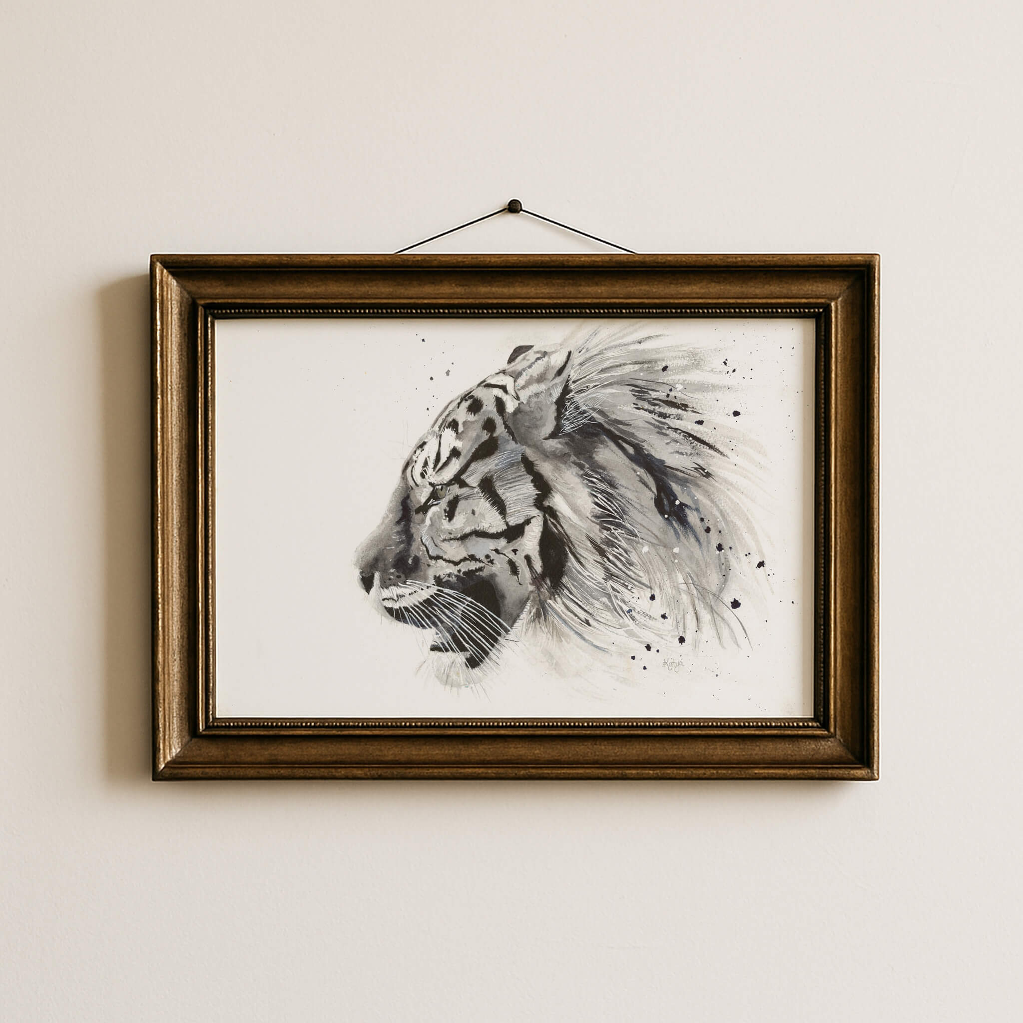 Untamed black and white tiger print in an antique gold frame, hanging on a neutral wall