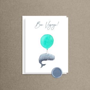 Bon voyage card with a watercolor whale lifted by a turquoise balloon, white envelope, and dusty blue "And So the Adventure Begins" wax seal